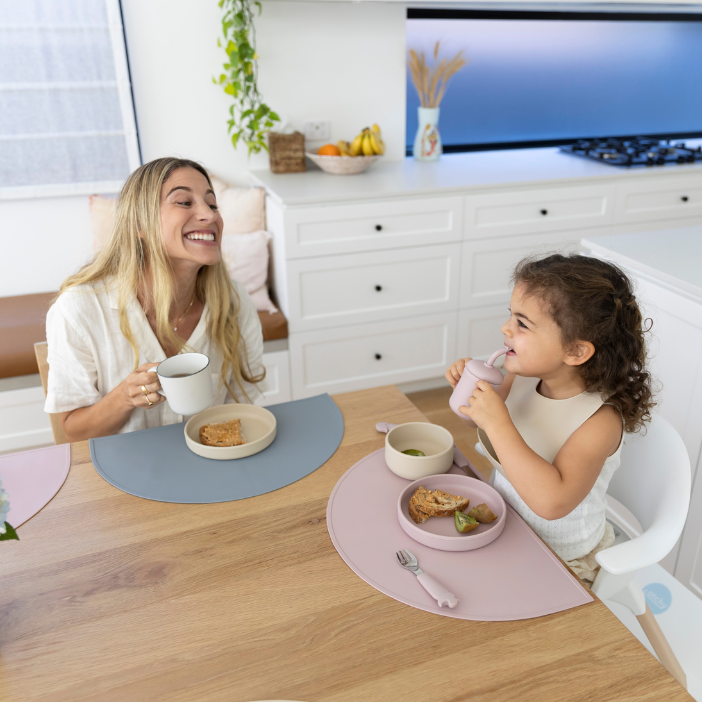 Mom and toddler eating at table with mess-free silicone placemats, easy clean food catcher for meals