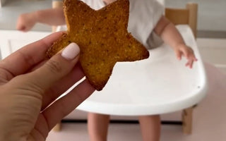 Star-shaped toast offered to baby in high chair, mess-free mealtime solution