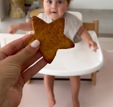 Star-shaped toast offered to baby in high chair, mess-free mealtime solution